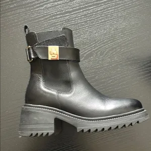Steve Madden Black Leather Ankle Boots with gold accent.